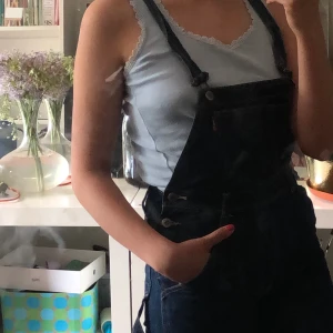 MÖRKBLÅA HÄNGSELBYXOR - Jätte snygga mörkblåa hängselbyxor. Köpta förra sommaren, men aldrig använt. Är i ankellängd. Möts gärna upp i Västerås men frakt funkar även. 63kr frakt