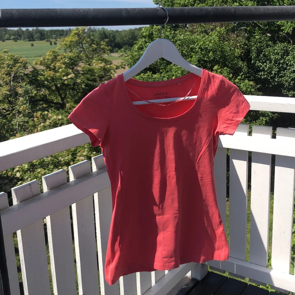 Corallröd t-shirt i organic cotton med tight passform. T-shirts.