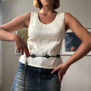 Vintage vit topp med detaljer - En jättefin vintage topp i vitt tyg med elefantdetaljer och lite utav en 90s fit. Perfekt för den där Julia Roberts looken från ”Notting Hill”. Jag är en storlek 36/38 och den passar nog bäst en 34/36 pga lite tight över bröstet.