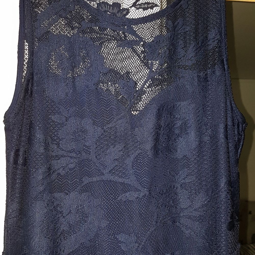 Mörkblå medellång klänning i blommigt spetstyg. Klänningen är i storlek 40 och är bra i storleken, inte för stor för att vara en 40. Jag har själv köpt den begagnad men den är i ett fint skick.. Klänningar.