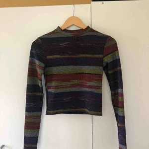  - Glittrig långärmad tröja från Urban Outfitters. Jättecoola färger, är i storlek S och nyskick. Köparen står för frakt.