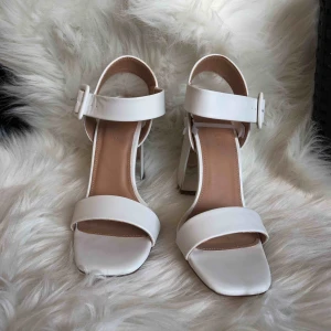  - Assnygga vita eleganta klackskor med en ”spegel” detalj på innersidan utav klacken