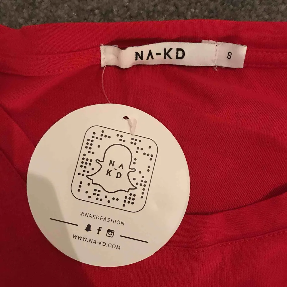 Röd t shirt från nakd, aldrig använd och prislappen är kvar, frakten ingår i priset . T-shirts.