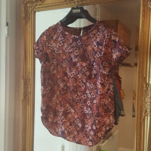  - Fin blus t-shirt ifrån H&M. Den knäpps i ryggen med en liten knapp och har en liten ficka framtill. Sömmarna har släppt i ärmarna men inget jag har stört mig på men därav priset. Frakt tillkommer annars kan jag mötas upp i Örebro.