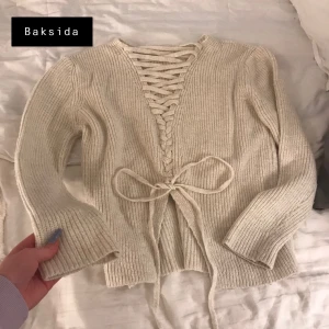 Tröja - Beige-vit stickad tröja med knytning i ryggen. Mjukt skönt material, plagget är i gott skick. Skriv privat för fler bilder/mer info 💙