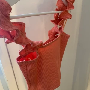 Volang topp - En volang topp från Zara. Finns i två färger, en svart och en peach färgad. Båda är cropped. En topp för 50kr och två för 80kr. Aldrig använda & passar även som (S) SMALL. Tvättar innan säljning. Köparen står för frakten. Vid frågor hör gärna av er !🤍💕💞