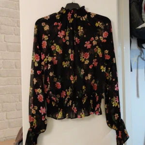 Genomskinlig blus - Genomskinlig svart blus med blommor. Från Bikbok stl M