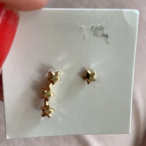 Örhängen stjärnor guld - Ett örhänge som är som en stjärna och ett som är tre stjärnor som hänger. Helt nya! Först till kvarn, iFrakt 15kr