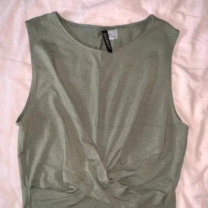 Grönt linne med knyte på framsidan - Fint militär grönt linne med knyte på framsidan! Inte använd. 