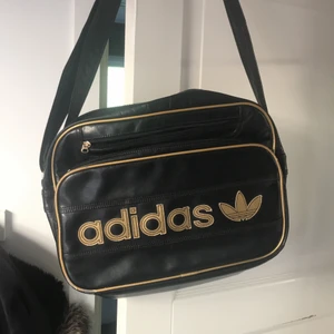 Adidas väska  - En adidas Väska med guld detaljer, 3fickor 🧳 Har även ett axelband 👍🏽Fint skick (andväbts fåtal gånger)