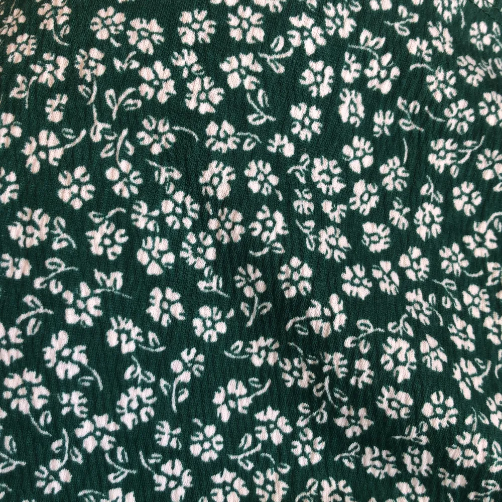 Grön klänning med vita blommor från H&M. Helt slutsåld! Storlek M men passar en S då jag sytt in den lite och det går att sy in mer! Kort i modellen. Tänk er ihop med en skinnjacka och boots!! 😍 150kr eller budgivning.. Klänningar.