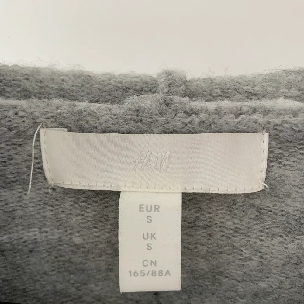 Säljer denna gråa stickade hoodie från H&M i storlek S, är jättemjuk och superskönt! (Köparen står för frakt). Stickat.