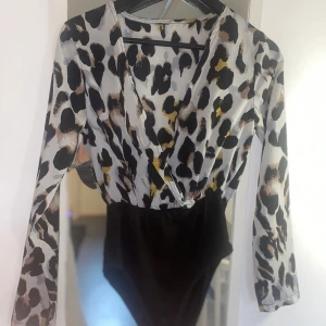 Body - Super fin ”blus” bodyn gjort för en högmidjad underdel funkar till alla möjliga tillfällen. Själva tröjan är i luftigt nästan kostymtyg och underdelen är ett mjukt tyg som sitter fint. Sömmen i mitten framhäver även väldigt fina former. 