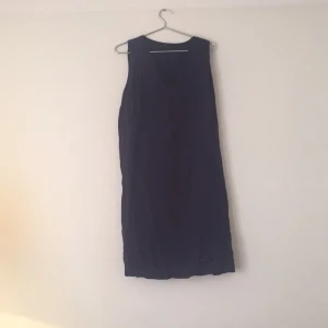  - Mörkblå klänning med v-ringning. Knälång (på mig, är 170cm). Från Åhléns.