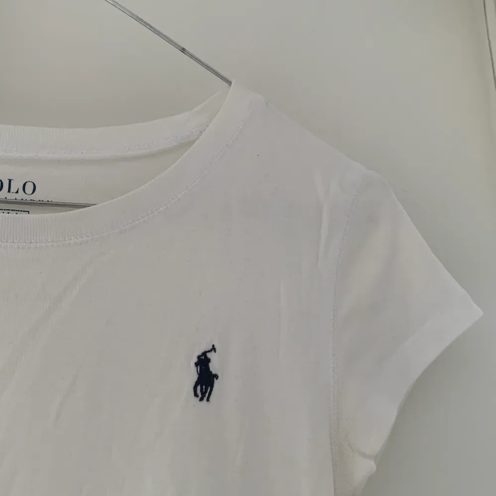 En vit Polo Ralph Lauren t-shirt med blått märke på ena sidan                    Köparen står för frakten . T-shirts.