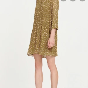 Blommig klänning från Samsoe Samsoe  - Säljer en vitblommig klänning från Samsoe Samsoe. Knappar att knäppa upptill på framsidan. 100 % viskos. Finns en avtagbar underklänning. Ordinarie pris 2199 kr 