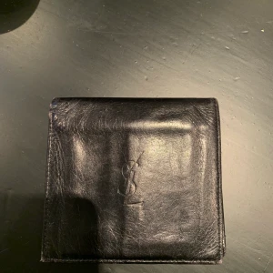 YSL plånbok - YSL plånka i mycket bra skick! Box finns kvar och kan skickas med. Bud börjar på 600