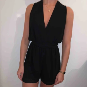  - Svart playsuit som kan knytas på valfritt sätt