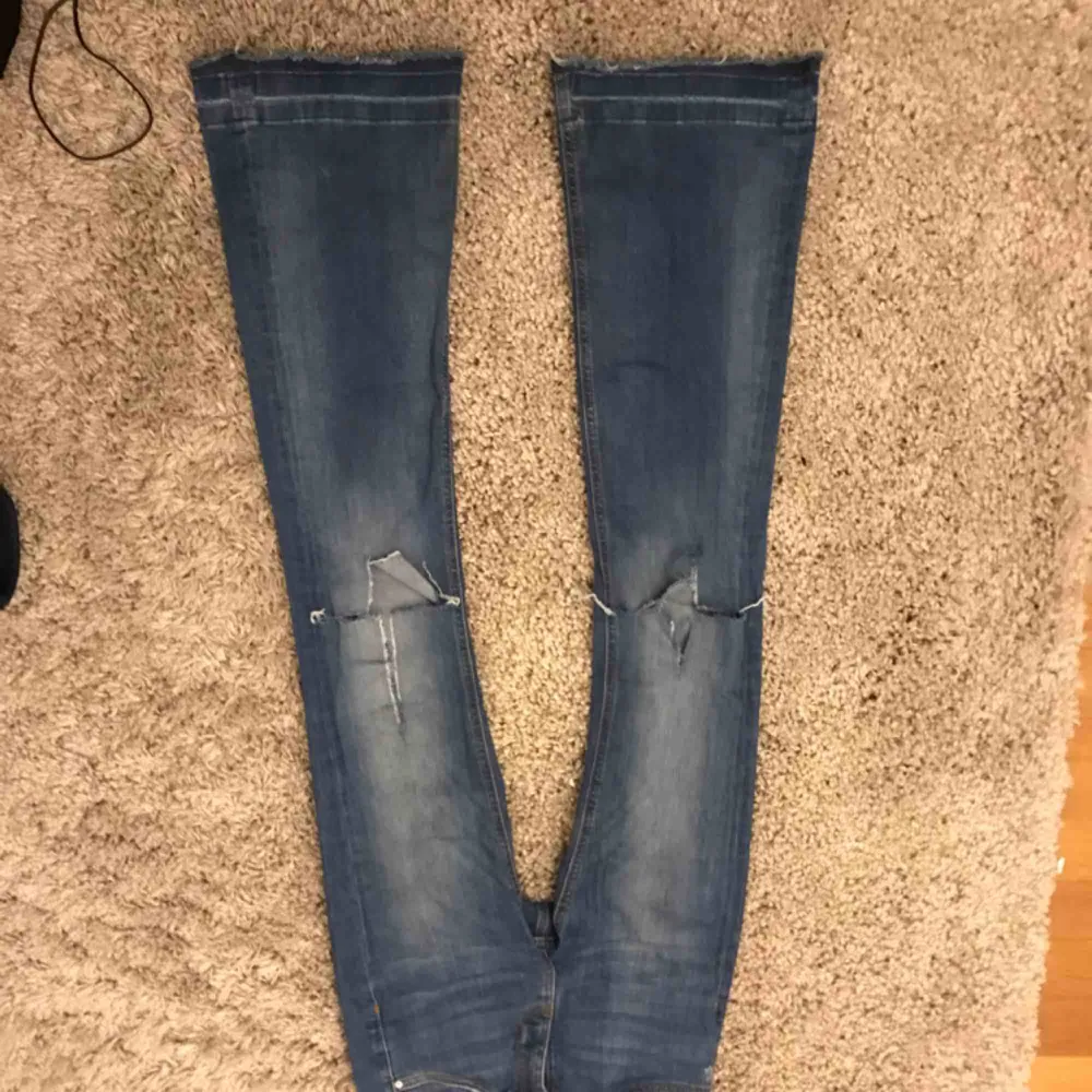 Super snygga bootcut jeans från zara med hål på knäna. . Jeans & Byxor.