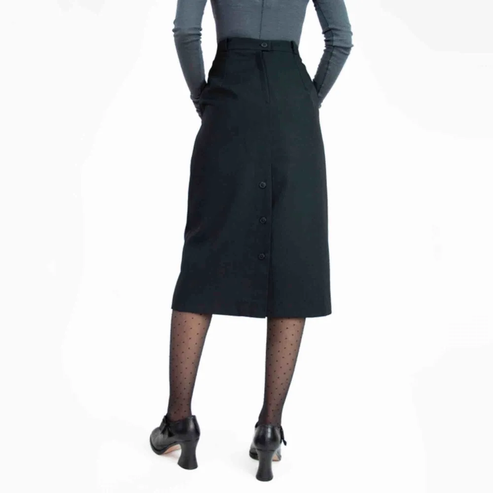 Vintage 70s wool blend buttoned back slit midi skirt in black SIZE Label: 36, fits best S Model: 165/XS big in her Measurements (flat): length: 72 waist: 33 hips: 49 Free shipping! Read the full description at our website majorunit.com No returns. Kjolar.