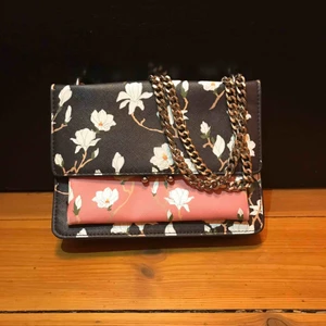  - En blommig handväska ifrån mango med en jättefin rosa färg i mitten. Väskan har 3 olika fack. Köpt för 3 år sedan men i superfint skick.  Kan frakta om köparen står för kostnaden. Skriv om du undrar något! :)