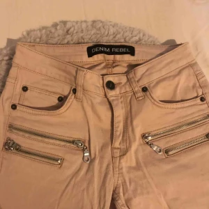  - Rosa- beige byxor med låg midja. Har dragkedjor som detaljer, även nere vid byxorna. Köparen står för frakten och betalningen sker via Swish👍