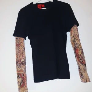  - Skitball t-shirt med inbyggd långärmad tröja som ska likna  sleeve tattoos typ. Märket är "Amal Guessous" och Nypris var: 1995 kr. 