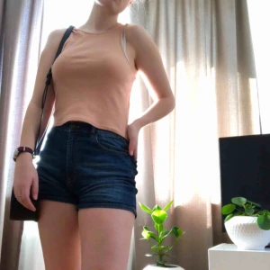  - Somrig haltertop i beige-rosa nyans. Ribbat tyg. Superfin med jeansshorts för en somrig outfit!