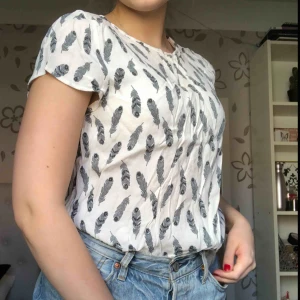  - Vit bekväm blus med fina grå fjädrar. Köparen står för frakt ☺️