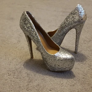  - Vill sälja ett par silver glittriga klakar  