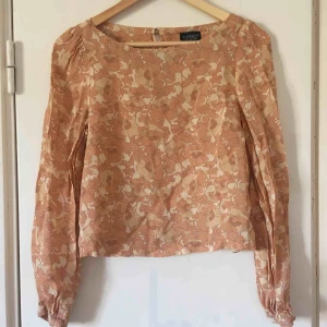  - Somrig top med vallmoblommor som mönster. Ganska kort modell. Första bilden återger färgen bäst!