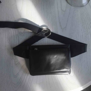  - Svart skinnväska som är lite mindre men med bra utrymme och kan användas som plånbok. Oerhört bra skick, syns inget slit och kan användas runt midjan samt som magväska som hänger över magen.
