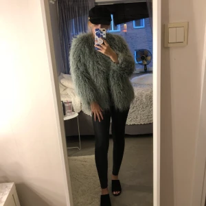  - Grön fakepäls som knappt är använd. Väldigt skön och varm. Fakepälsen liknar ull. 