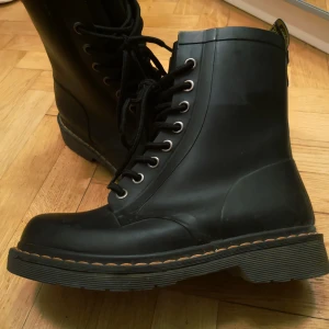 - Dr. Martens i strlk 38 (men är små i storleken) i gummistövelmaterial. Köpta för många år sedan men inte använt ofta. Säljer för använder inte längre och de är lite för små för mig. Det syns att de inte är nya men är inte skadade, kan skicka bilder.  Kan mötas i Stockholm eller posta, köparen betalar för frakt
