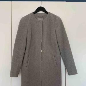  - Ljusgrå kappa.  Använd fåtal gånger, därmed mycket fint skick.  Köpare står för frakt :)