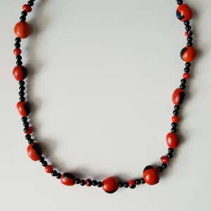 - Halsband med svarta och orangea träpärlor. Fraktkostnaden blir 9kr.