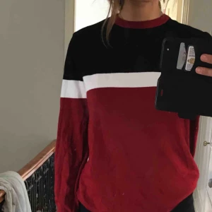  - Fin långärmad tröja i färgerna svart, vit och röd.