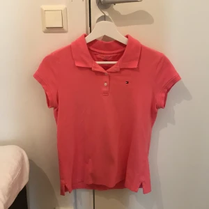 Piké Tommy Hilfiger - En rosa knappt använd piké från Tommy Hilfiger. Storlek 16 år. Frakt tillkommer