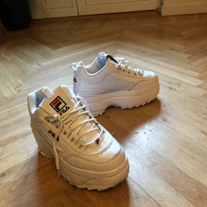 Fila skor  - Ett par vita fila skor med tjock sula i ganska bra skick, använda några gånger och säljer pga att de blivit för små! Kan frakta (frakten ingår i pris) dom men även mötas upp i Stockholm!