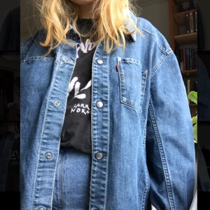 Levis Jeansjacka - Vintage Levis jeansjacka i mycket gott skick!Storleken är XL vilket gör att den passar många olika kroppsformer beroende på vilken passform man vill ha! Jackan stängs med tryckknappar och har två fickor fram.