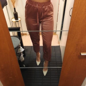 Formella mjukisbyxor - Mjukisbyxor som lätt kan användas till vardags/fest då dem är riktigt stilrena/formella. Snygg kopparfärgad. Strl. 36. Snygg slits nedtill.