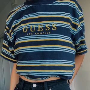 Guess T-shirt  - T-shirt från GUESS originals. Köpt på Urban Outfitters i Stockholm på herravdelningen och är därför en stor M. Fin att stoppa in eller sätta fast i toppen under (se bild) Nypris 55€ (575kr) 