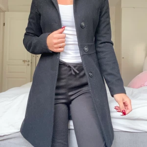 Kappa - Svart kappa från benetton, nypris 1999:- säljer för 300. Innehåller ull så den är varm på vintern! Strl XS. Köparen står för frakt. 