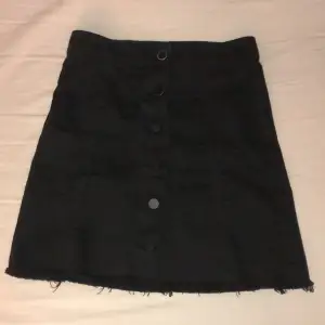 Superfin svart kjol med knappar från Ginatricot i storlek 34!
