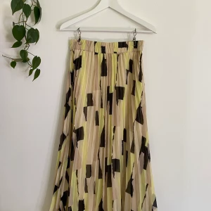 Mönstrad plisserad kjol, Monki - Plisserad kjol med resår i midjan. Använd fåtal gånger. Går ungefär till strax under vaderna på mig som är 165cm lång. Frakt tillkommer (59kr). 