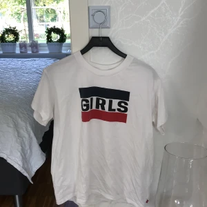 Levis t-shirt i storlek M - Det är en snygg vit t-shirt med blått och röt tryck. jätte snygg att ha till ett par ljusa jeans eller ett par svarta kostym byxor. Kan kläs upp eller ner. bra plagg att ha 😉 betals via swich :) 