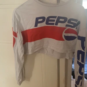 H&M STRL XS - Cropped tröja, med Pepsi på. Välanvänd, finns lite slitage på det röda (syns i bilden). Funkar att ha på sig när som helst, vid träning, vardag, ut och äta.