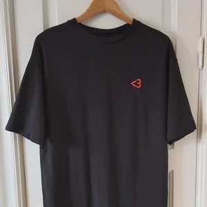 Oversized t-shirtklänning - Svart oversized t-shirtklänning. Cool brodyr som ser ut som ett hjärta <3. Vet inte vad det är för storlek, klippt lapparna, men passar de flesta beroende på hur oversized man gillar. Mellan XXS-L för oversized fit. Slutar 8cm över knäna på mig, är 167cm.