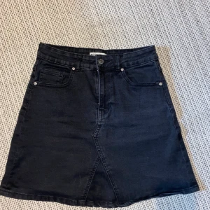 Svart jeanskjol - Svart jeanskjol från Gina Tricot i storlek 38, stretchig och super skön. Säljer då den inte kommer till användning, köpt förra sommaren och använd ett tiotal gånger. 50+frakt!