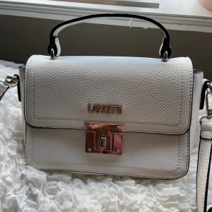 Trendig, vit handväska🦋 - Säljer en populär och fin handväska🦋 Skinnimitation (EJ äkta skinn) Köpte för 400 kr i Italien🦋 Fack inuti med dragkedja Buda!!!